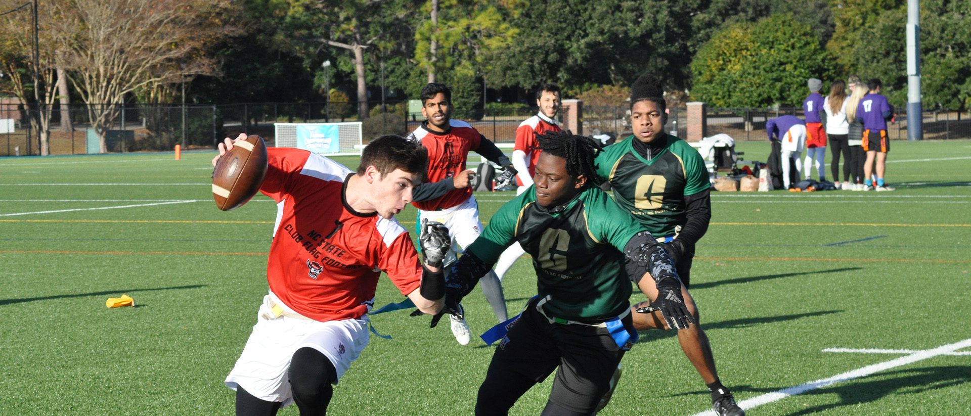 flag football player trying to pull flagg of other player with the ball