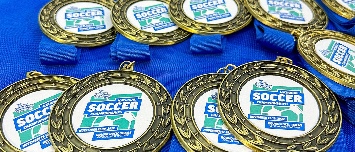 close up of medals with NIRSA Soccer logo on a blue tablecloth