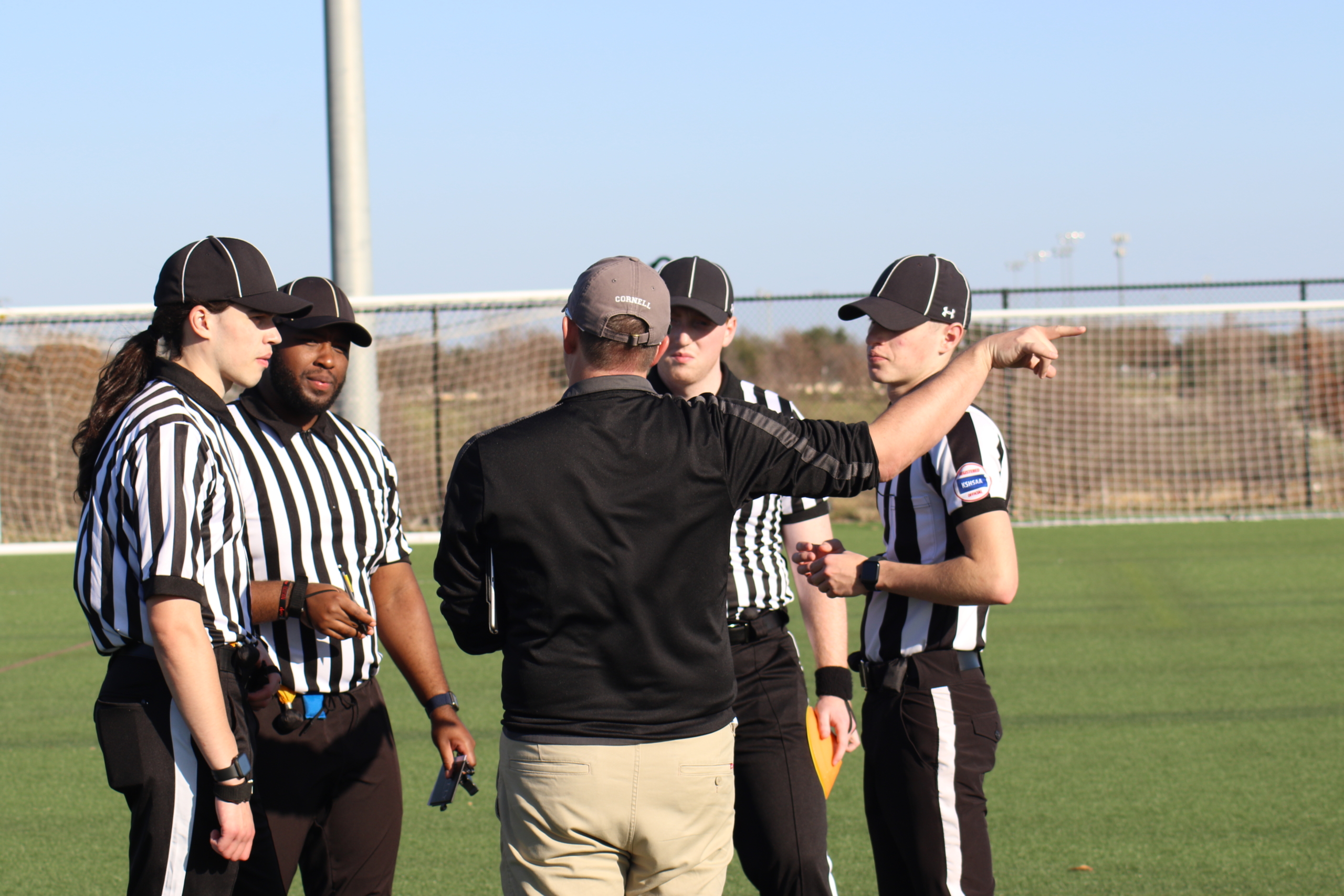 Group of flag football officials, in a group huddle